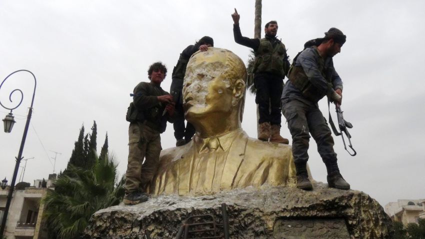 This image has an empty alt attribute; its file name is syria.assad-statue-destroyed1.jpg